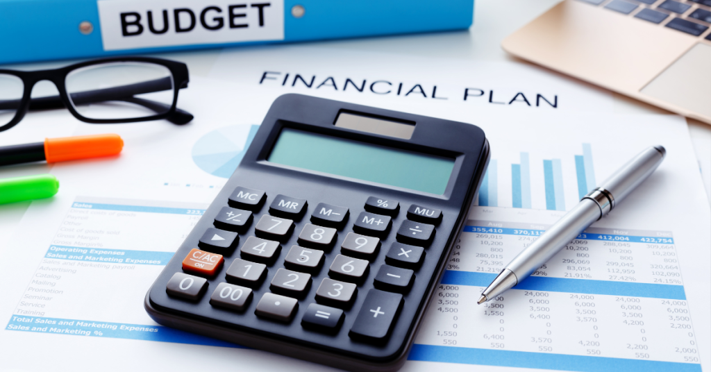 Calculator and glasses on a budget and financial plan binder