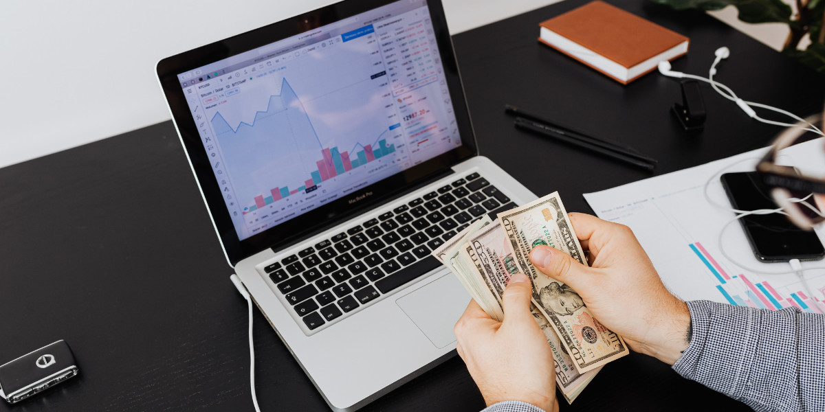 TWM Person counting cash beside laptop