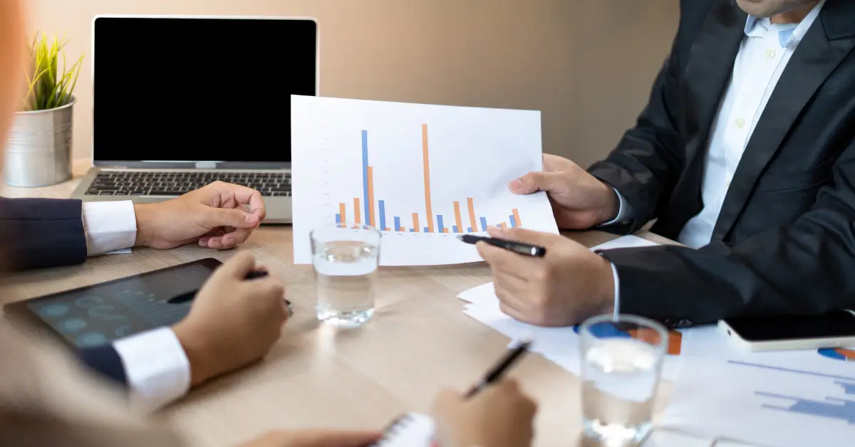 Untitled design (52) Business professionals discussing financial charts and analyzing performance data during a meeting.